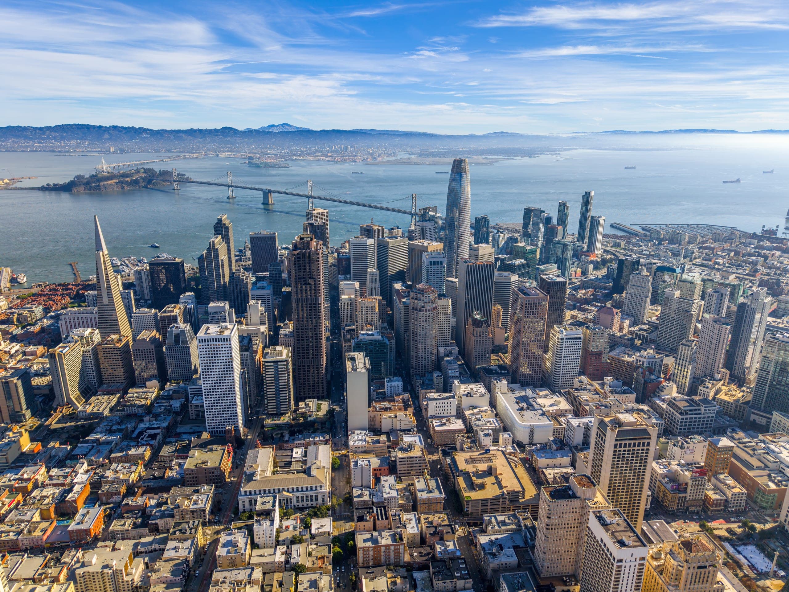 Aerial view of the San Francisco Financial District, with the Bay Bridge and the Marin hills beyond