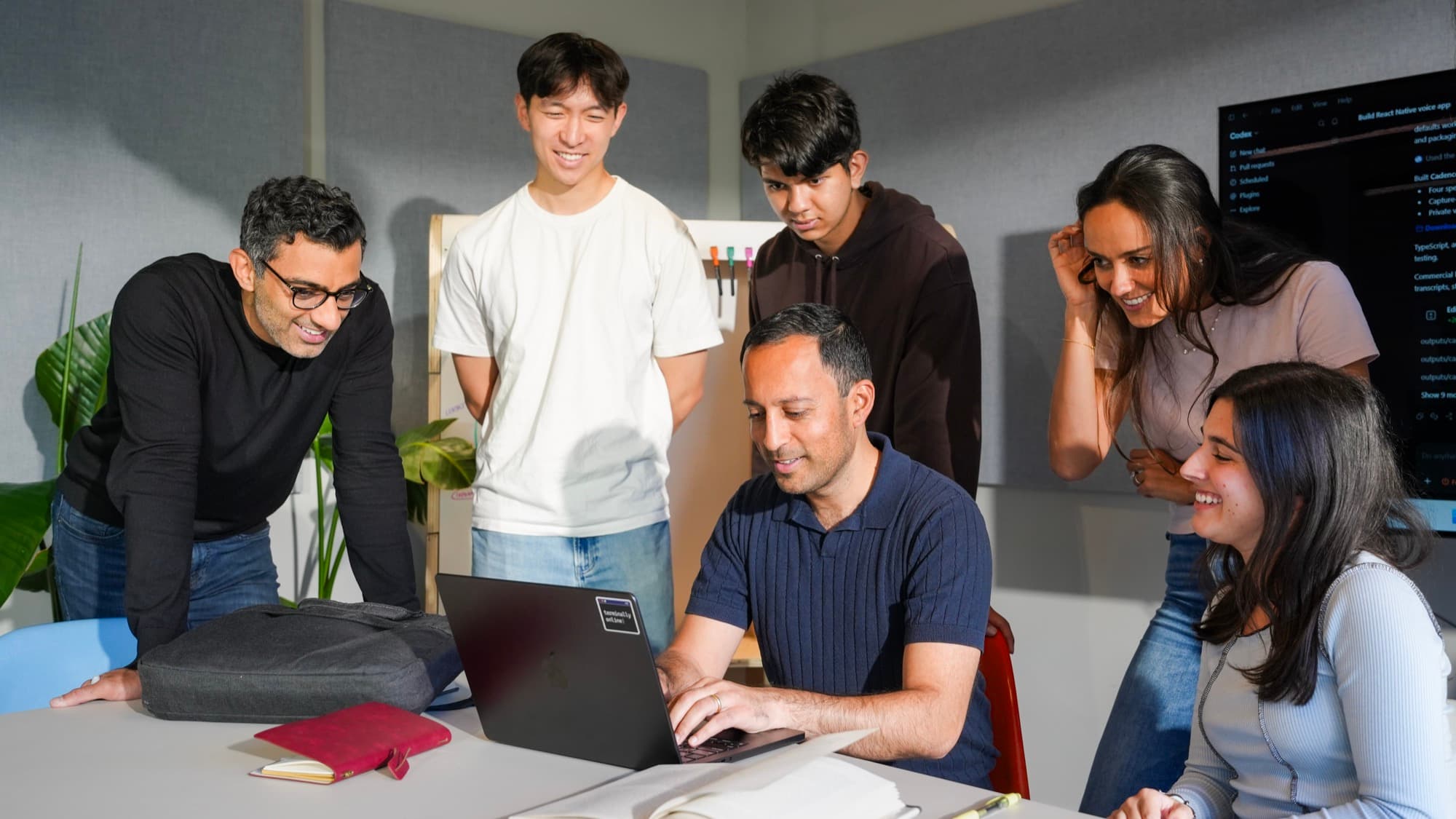 People building together around a laptop